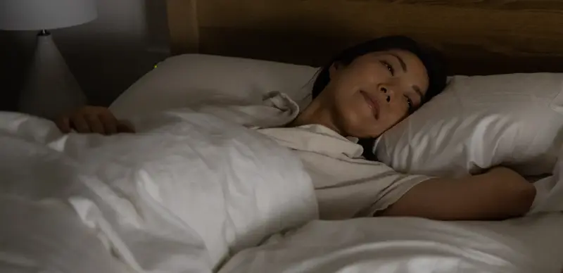 woman laying on bed waking up